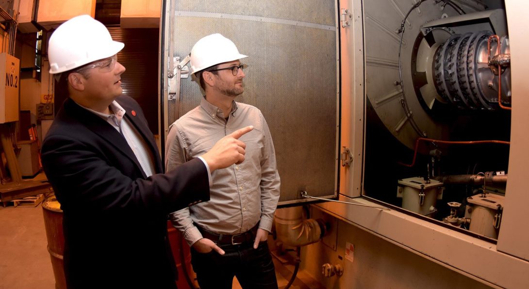 Cliff Haefke, director of the UIC Energy Resources Center, left, and policy analyst Graeme Miller analyze the 7-megawatt combined heat and power combustion turbine at the UIC West Campus Utilities Plant.